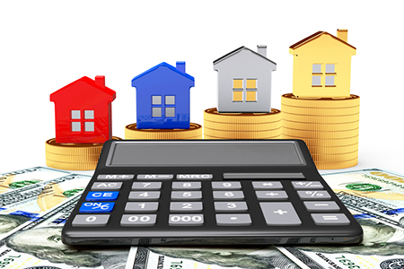 Different houses on stacks of golden coins and calculator on dollar bills